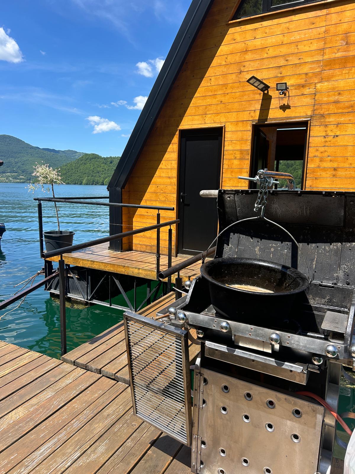 Roštilj i kazan na terasi splava sa pogledom na jezero